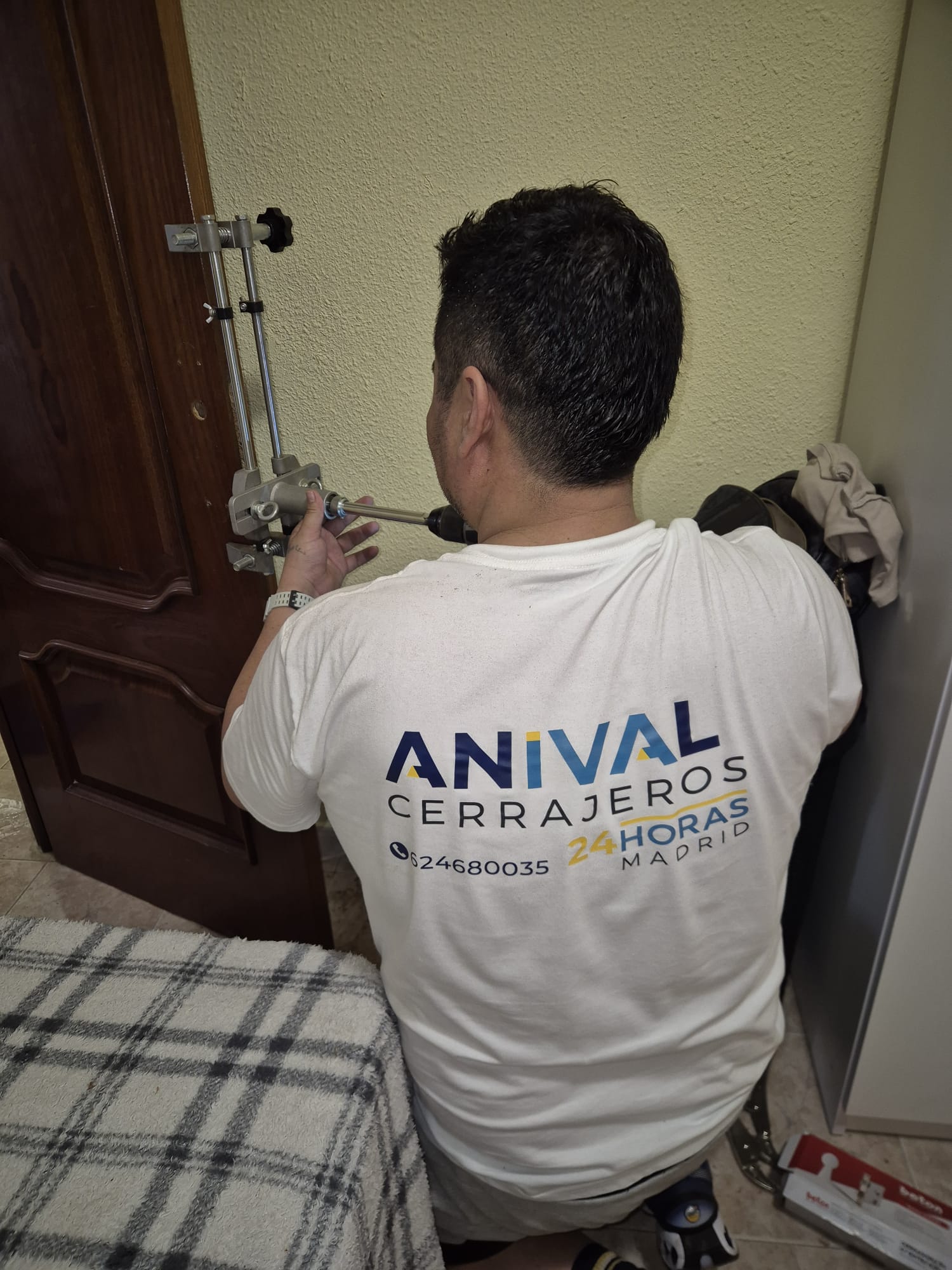 Anival Garvizu instalando una cerradura en una puerta de Madrid, servicio de cerraduras inteligentes